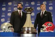  ?? JOHN BAZEMORE — THE ASSOCIATED PRESS ?? Ohio State head coach Ryan Day, left and Georgia head coach Kirby Smart stand with the trophy during a news conference ahead of Saturday’s Peach Bowl on Friday in Atlanta.