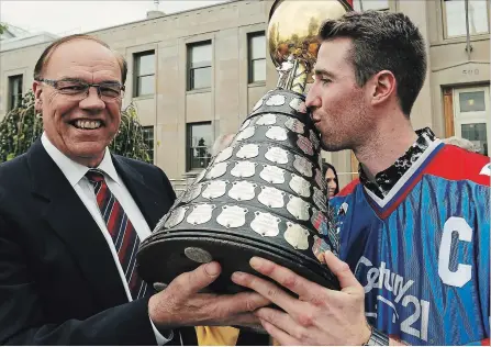  ?? CLIFFORD SKARSTEDT EXAMINER ?? Peterborou­gh Lakers captain Robert Hope kisses the Mann Cup to Mayor Daryl Bennett outside City Hall during the Mann Cup parade on Oct. 14.