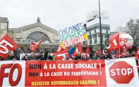  ?? (AFP) ?? Empty platforms (left) are seen at the Saint Jean train station in Bordeaux, as striking railway workers protested across the country; a group of workers (right) protest waving flags and carrying banners in front of the Gare de L'Est train station on...