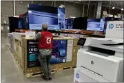  ?? DAVID ZALUBOWSKI — THE ASSOCIATED PRESS ?? An associate checks over a big-screen television on display in a Costco warehouse in Colorado Springs, Colo., on Feb. 6.