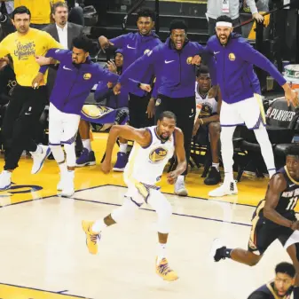  ?? Carlos Avila Gonzalez / The Chronicle ?? The Warriors’ bench reacts after a Kevin Durant basket in the second quarter. Golden State started its so-called Hamptons 5 lineup for the second game in a row, with the same result.