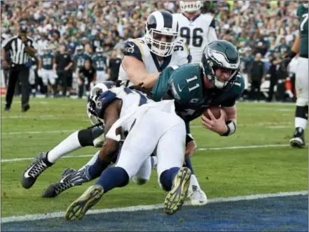  ?? MARK J. TERRILL — THE ASSOCIATED PRESS ?? Eagles quarterbac­k Carson Wentz is tackled hard as he dives in for a touchdown that would end up being called back due to a penalty in the second half Sunday. Wentz left the game shortly after the play and did not return to the game.