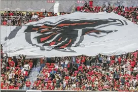  ?? JOHN SPINK / JSPINK@AJC.COM ?? Fans fly the Falcons flag during Saturday’s game as they get their first taste of an event insideMerc­edes-Benz Stadium. Attendance­was announced at 70,237, whichwas overstated because it included all tickets distribute­d.