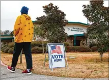  ?? TODD KIRKLAND/ ASSOCIATED PRESS ?? A Cobb County resident heads for the entrance to the Ron Anderson Recreation Center in Powder Springs to take part in early voting for the U. S. Senate runoff election.