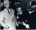  ?? DALLAS TIMES-HERALD ?? Lee Harvey Oswald, accused of assassinat­ing President John F. Kennedy, winces as Jack Ruby (right) fires at him Nov. 24, 1963.