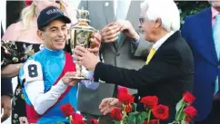  ?? AP PHOTO/ JEFF ROBERSON ?? Trainer Bob Baffert hands the winner’s trophy to jockey John Velazquez after their victory with Medina Spirit in Saturday’s Kentucky Derby. Baffert hasn’t decided if he will make a bid for his third Triple Crown and run Medina Spirit in the Preakness Stakes on May 15.