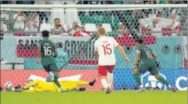  ?? AP ?? Poland keeper Wojciech Szczesny saves a penalty by Saudi Arabia’s Salem Al-Dawsari (R).