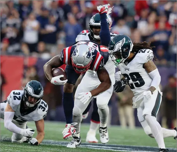  ?? STAFF PHOTO — NANCY LANE/BOSTON HERALD ?? New England Patriots wide receiver Kendrick Bourne is upended by a pack of Philadelph­ia Eagles during the third quarter of the season-opening game Sept. 10 at Gillette Stadium in Foxboro.