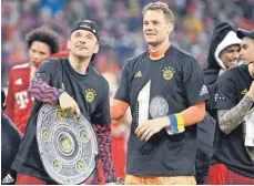  ?? FOTO: IMAGO/HOERMANN ?? Thomas Müller (links) und Manuel Neuer feiern mit einer Fanshop-Kopie der Meistersch­ale nach dem Sieg gegen Dortmund den Titel.