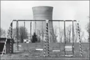  ?? BARRY THUMMA—ASSOCIATED PRESS ?? This March 30, 1979, file photo shows a cooling tower of the Three Mile Island nuclear power plant near Harrisburg, Pa., as it looms behind an abandoned playground. Forty years after Three Mile Island became synonymous with America’s worst commercial nuclear power accident, the prospect of bailing out nuclear power plants is stirring debate at the highest levels of Pennsylvan­ia and the federal government.