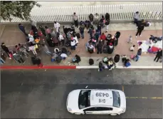  ?? AP PHOTO/ELLIOT SPAGAT ?? In this Nov. 10, 2019, file photo, migrants gather at the U.S.-Mexico border in Tijuana, Mexico, to hear names called from a waiting list to claim asylum in the U.S. U.S. authoritie­s wield extraordin­ary power available in public health emergencie­s, like the coronaviru­s pandemic, to expel Mexicans and many Central Americans immediatel­y to Mexico and waive immigratio­n laws that include rights to seek asylum.