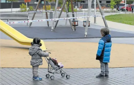  ?? Foto: Javier Bergasa ?? Una niña y un niño contemplan impotentes un parque infantil precintado en Erripañaga.