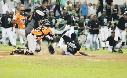  ??  ?? Alfredo Reyes, de las Estrellas, se desliza a salvo en el plato con la carrera del empate tras un lanzamient­o descontrol­ado del relevista Héctor Neris.