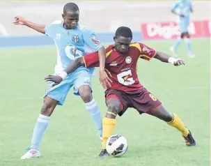  ??  ?? Wolmer’s Boys’ Tazeo Gilpin ( right) shielding the ball from St George’s College’s Cardel Benbow during last year’s Manning Cup semi- final at the National Stadium. The teams will meet in a rematch tomorrow.