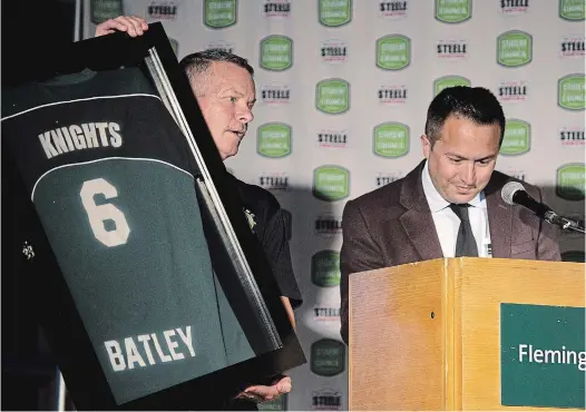  ?? JESSICA NYZNIK EXAMINER ?? Fred Batley holds up an honorary jersey — that will hang in Fleming College — during his retirement party at Fleming College on Tuesday.