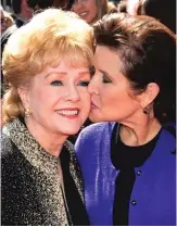  ?? AP FILE PHOTO ?? Carrie Fisher kisses her mother, Debbie Reynolds, as they arrive at an awards ceremony in 2011 in Los Angeles. Fisher and Reynolds died one day apart in late December 2016.