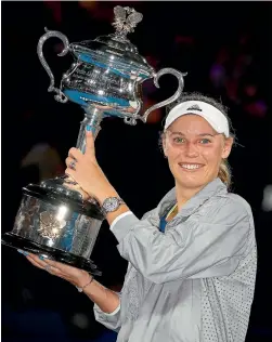 ?? PHOTO: GETTY IMAGES ?? Caroline Wozniacki and the spoils of her Australian Open title success after beating Simona Halep in the women’s final in Melbourne on Saturday night.