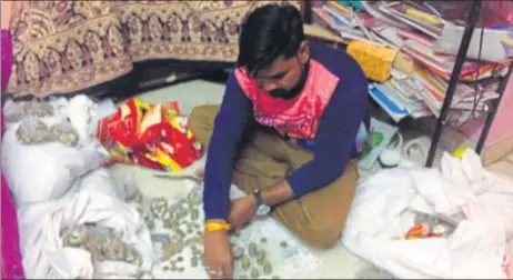  ?? HT PHOTO ?? ▪ (Above and below) A trader counting his stock of coins as banks have imposed an undeclared ban on deposit of coins which has left small businessme­n in a fix.