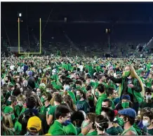  ?? (AP pool photo/Matt Cashore) ?? Fans storm the field Saturday night after Notre Dame defeated top-ranked Clemson in South Bend, Ind. Notre Dame President John Jenkins told all of the school’s students that they are required to undergo coronaviru­s testing before they leave for an extended winter break.