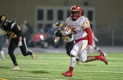  ?? Harrison Jones photos/For the Post-Gazette ?? Penn Hills’ Terry Smith, right, breaks free on his way to a touchdown in the first half of the Indians’ PIAA Class 5A semifinal win against Archbishop Wood Friday night at Chambersbu­rg High School. Below: Penn Hills’ Richard Martin scores a touchdown.