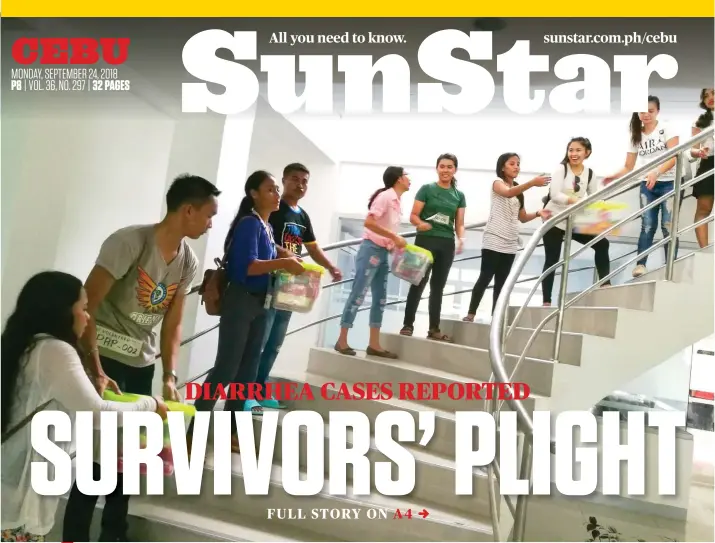  ?? SUNSTAR FOTO / ALEX BADAYOS ?? HELP FOR THE LIVING. Student volunteers haul relief goods at the Naga City Hall for the more than 100 families affected by the landslide that struck Sitio Sindulan, Barangay Tina-an early morning last Thursday.