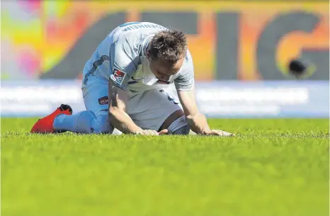  ?? FOTO: DPA ?? Muss wieder aufstehen: Der Heidenheim­er Arne Feick kniet auf dem Rasen des Max-Morlock-Stadion.