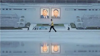  ?? AFP ?? Líderes. Retratos de dos fundadores del régimen, Kim il-Sung y Kim Jong-II, en una calle de Pyongyang.