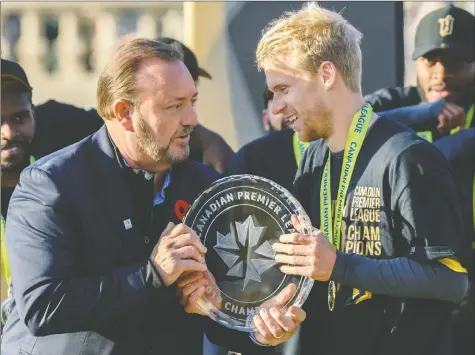  ?? AZIN GHAFFARI ?? Commission­er David Clanachan hands the CPL trophy to Forge FC captain Kyle Bekker last year.