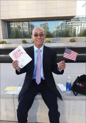  ?? MARY MUNNELL — CONTRIBUTE­D ?? Win Naing holds up a U.S. flag at his naturaliza­tion service when he gained citizenshi­p on Sept. 2, 2016, outside the U.S. District Court building in Las Vegas.