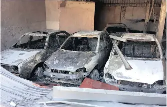  ??  ?? VEHICLES brought in for repairs at a workshop in Springfiel­d Park were set alight by community members who invaded the premises during a protest yesterday.