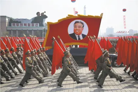  ?? Wong Maye-E / Associated Press ?? North Korean soldiers carry flags and a photo of late leader Kim Il Sung as they march in a military parade in Pyongyang.