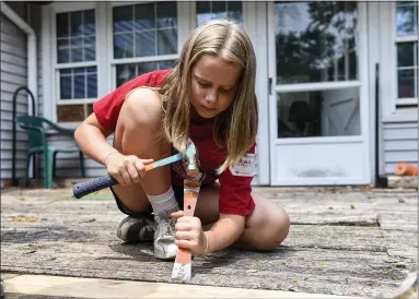  ?? BEN HASTY — MEDIANEWS GROUP ?? Hannah Blankenbil­ler, 12, helps to repair a deck in Amity Township as part of Mission Week Birdsboro.