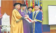  ??  ?? Masir (left) presents a certificat­e to Paul Bar, the ‘Best Apprentice’ under the menswearma­king programme, from Limbang Prison.