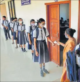  ?? PRAFUL GANGURDE/HT ?? Students being screened and sanitised before entering their classroom at a school in Kasheli village in Bhiwandi, Thane.