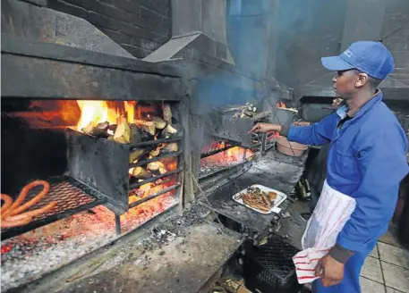  ?? Picture: ESA ALEXANDER ?? HOT STUFF: A staff member prepares meat for patrons at Mzoli’s Place in Gugulethu, Cape Town