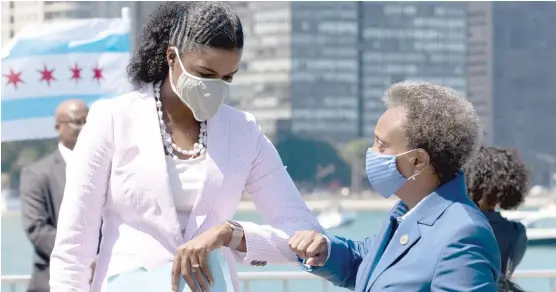  ?? PAT NABONG/SUN-TIMES ?? Cook County State’s Attorney Kim Foxx and Mayor Lori Lightfoot share an elbow bump Friday, days after the mayor called on Foxx to take a harder line on looters.