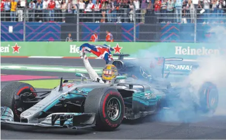 ?? FOTO: AFP ?? Weltmeiste­rliche Donuts: Lewis Hamilton weiß seinen vierten Titel nach der Zieldurchf­ahrt gebührend zu feiern.