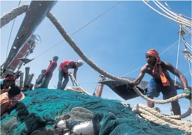  ??  ?? Migrant labourers work on a fishing boat docked at a pier in Phangnga province in southern Thailand.