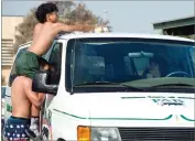  ??  ?? Jaden Fuentes, top, washes the roof of the van with the help of Josh Newsom Saturday.