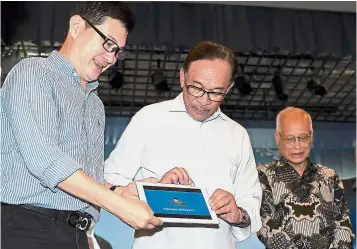 ??  ?? Learning made easy: Anwar (centre) launching the free e-tuition portal in Port Dickson. With him are Yee (left) and Tan Sri PanglimaDr Abdul Rahman Arshad.