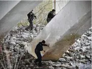  ?? MARSHALL GORBY / STAFF ?? Dayton police and Montgomery County Sheriff’s deputies search for suspects Tuesday under the bridge at the Stillwater River. The suspects were found hours later, hiding about a block from the river.