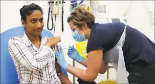  ?? University of Oxford via AP ?? In this screen grab from video issued by Britain’s Oxford University, a volunteer is injected with either an experiment­al COVID-19 vaccine or a comparison shot as part of the first human trials in the U.K. to test a potential vaccine, led by Oxford University in England on April 25. About 100 research groups around the world are pursuing vaccines against the coronaviru­s, with nearly a dozen in early stages of human trials or poised to start.