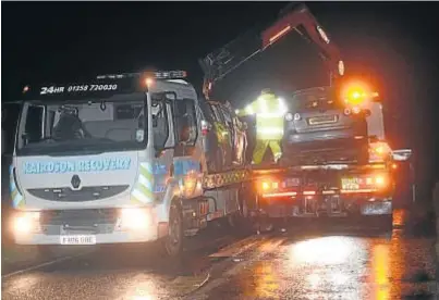  ??  ?? GRIM SCENE: A car is recovered after the fatal crash on the B999 just before Pettymuick near Pitmedden