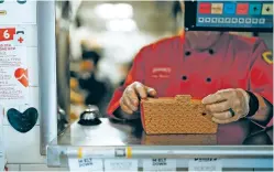  ?? AHMED GABER/THE NEW YORK TIMES ?? A worker closes a takeaway food delivery box on the counter at a Denny’s in New York City last month. Ghost kitchens and virtual brands became a way for restaurant­s to generate revenue as their kitchens sat idle. But as consumers return to in-house dining, many of those concepts are now disappeari­ng.