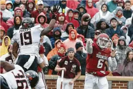  ?? Alonzo Adams / Associated Press ?? OU quarterbac­k Baker Mayfield, right, torched Oklahoma State with his arm Saturday and afterward declared he’s returning next year for a title three-peat bid.