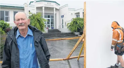  ?? PHOTO: RICHARD DAVISON ?? Seeking accountabi­lity . . . Chairman of the newly formed Clutha Residents and Ratepayers Associatio­n, John Fenby, stands in front of constructi­on workers fencing off the Balclutha War Memorial Hall in preparatio­n for a controvers­ial Clutha District Council project yesterday, which he says was a key factor in forming the new group.