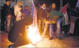  ??  ?? Palestinia­n demonstrat­ors burn the US flag in Bethlehem's Manger Square. ▪