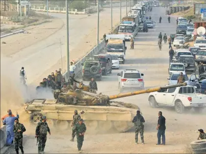  ?? / AFP ?? Militares sirios, ayer a la entrada de Harasta (Guta Oriental) durante la evacuación de los rebeldes.