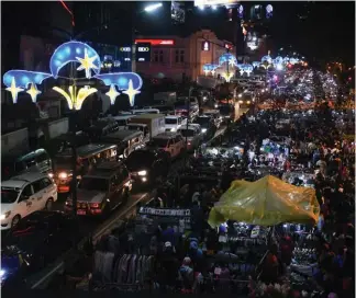  ?? Photo by Redjie Melvic Cawis ?? TOURIST COME ON. During the holiday season, thousands of tourists fill the Night Market along Harrison Road while the other part of the road is filled with vehicles. The City Council is studying a proposal transferri­ng the night market to Kayang Street.
