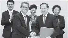  ?? ROY LIU / CHINA DAILY ?? Paul Chan (left), HK’s financial secretary, and Vice-Minister of Commerce Fu Ziying shake hands during the signing ceremony of the Mainland and Hong Kong Closer Economic Partnershi­p Arrangemen­t Agreement on Trade in Goods.